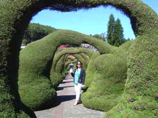 Tour participant standing among the giant topiaries in Zarcero, Costa Rica